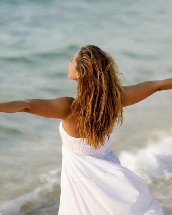 back-view-woman-feeling-free-while-standing-by-sea-with-her-arms-outstretched_Easy-Resize.com